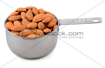 Whole unblanched almonds in a metal cup measure