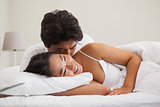 Couple lying in bed and cuddling