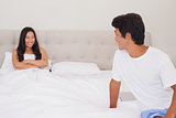 Couple smiling at each other at opposite ends of bed