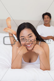Woman lying on bed smiling at camera