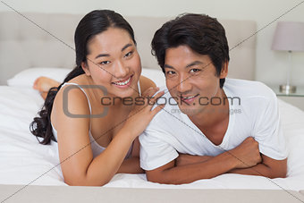 Happy couple lying on bed together