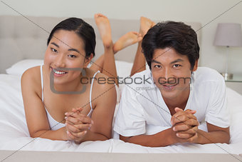 Happy couple lying on bed together
