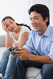 Woman being ignored by boyfriend playing video games