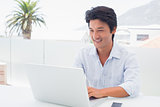Smiling man using his laptop