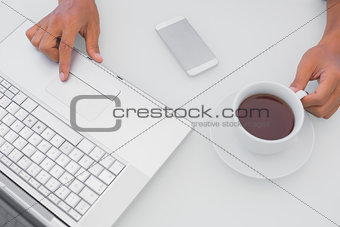 Man having coffee and using laptop