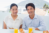 Smiling couple having breakfast together