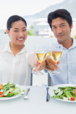 Happy couple having white wine with a meal
