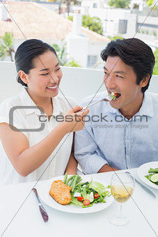 Happy couple having a meal together with white wine