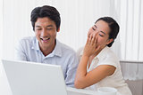 Happy couple using laptop together