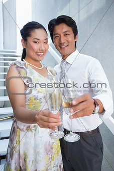 Happy couple dressed up for a date having champagne