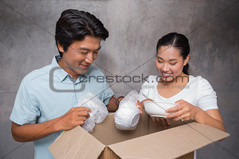 Happy couple unpacking moving boxes
