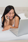 Happy woman looking at laptop on the phone