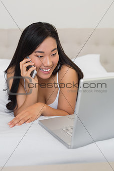 Happy woman looking at laptop on the phone