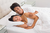 Smiling couple lying in bed