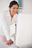 Casual businesswoman smiling at computer