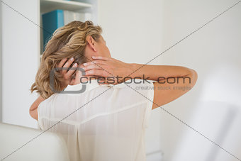 Casual businesswoman rubbing her neck