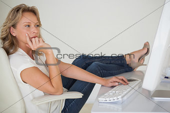 Casual businesswoman working with her feet up at desk