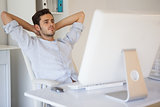 Casual businessman relaxing at desk leaning back