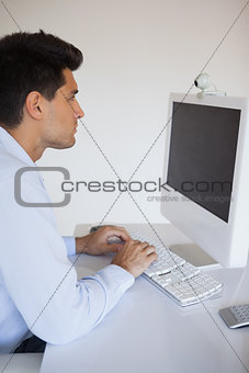 Casual businessman typing at his desk