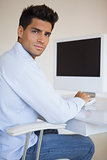 Casual businessman working at his desk looking at camera