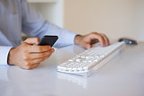 Businessman texting on phone at desk
