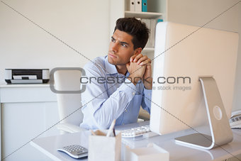 Casual businessman thinking at his desk