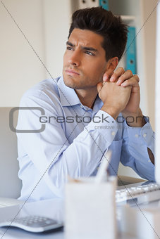 Casual businessman thinking at his desk
