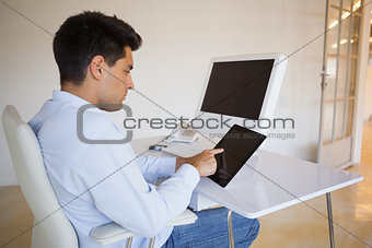 Businessman working on his tablet at his desk