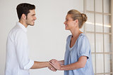 Casual business woman shaking hands with man