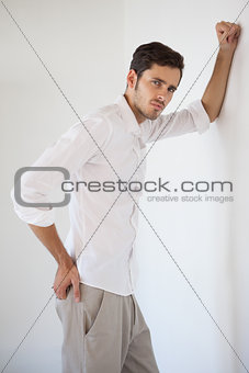 Casual businessman leaning against the wall