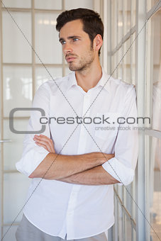 Casual upset businessman leaning against window
