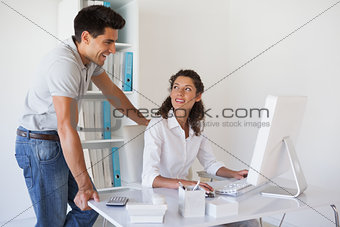 Casual businessman looking at colleagues computer