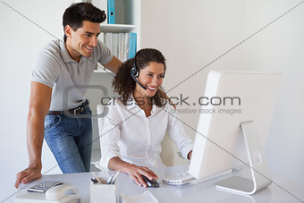 Casual businessman looking at colleagues computer