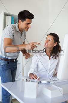 Casual business team smiling at each other at desk