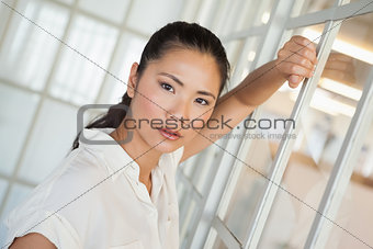 Casual frowning businesswoman leaning on window