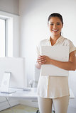 Casual businesswoman smiling at camera holding folder