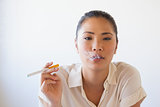 Casual businesswoman smoking an electronic cigarette