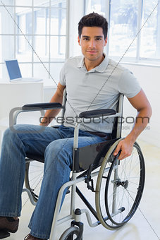 Casual businessman in wheelchair smiling at camera