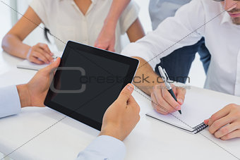 Casual businessman using his tablet during meeting