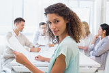 Casual businesswoman looking at camera during meeting