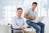 Casual businessman in wheelchair working with colleague