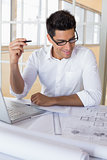 Casual architect working with laptop at desk