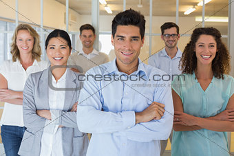 Casual business team smiling at camera with arms crossed
