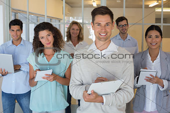 Casual boss standing in front of his team all taking notes