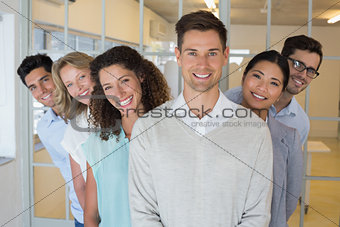 Casual business team smiling at camera together