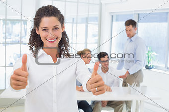 Casual happy businesswoman showing thumbs up to camera