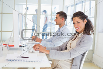 Casual pregnant businesswoman working at desk