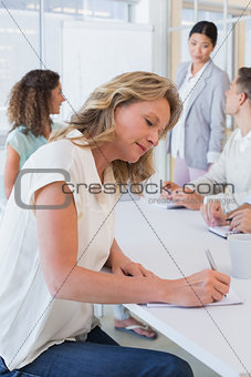 Casual businesswoman taking notes during meeting