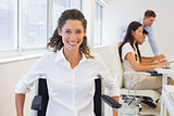 Casual businesswoman in wheelchair smiling at camera