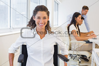 Casual businesswoman in wheelchair smiling at camera